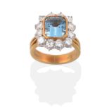 An 18 Carat Gold Aquamarine and Diamond Cluster Ring, an emerald cut aquamarine in a yellow rubbed