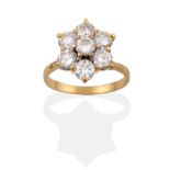 A Diamond Cluster Ring, seven round brilliant cut diamonds in yellow claw settings, to a tapered