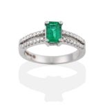 An 18 Carat White Gold Emerald and Diamond Ring, the emerald-cut emerald in a four claw setting,