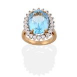 A 9 Carat Gold Blue Topaz and Diamond Cluster Ring, an oval cut topaz in a yellow four claw setting,