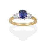 An 18 Carat Gold Sapphire and Diamond Ring, an oval mixed cut sapphire flanked by two tapered