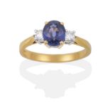 An 18 Carat Gold Sapphire and Diamond Three Stone Ring, the oval cut sapphire sits between two round