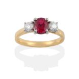 An 18 Carat Gold Ruby and Diamond Three Stone Ring, the oval mixed cut ruby flanked by two round