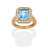 An Aquamarine and Diamond Cluster Ring, an emerald-cut aquamarine in a yellow four claw setting,