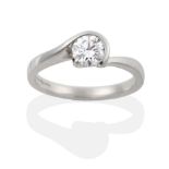 A Platinum Diamond Solitaire Ring, the round brilliant cut diamond in a swirl setting to offset