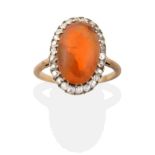 A Fire Opal and Diamond Cluster Ring, an oval cabochon fire opal within a border of old cut diamonds