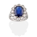 An 18 Carat White Gold Sapphire and Diamond Cluster Ring, an oval mixed cut sapphire in a claw