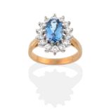 An 18 Carat Gold Aquamarine and Diamond Cluster Ring, an oval cut aquamarine within a border of