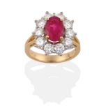 An 18 Carat Gold Ruby and Diamond Cluster Ring, an oval mixed cut ruby in a yellow four claw