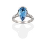 An Aquamarine and Diamond Ring, a pear cut aquamarine in a white semi-rubbed over setting to