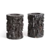 A Pair of Chinese Black Wood Brush Pots, Qing Dynasty, carved with figures amongst trees, 21cm