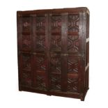 A 17th Century Joined and Carved Oak Cupboard, with four hinged doors carved with sixteen Gothic