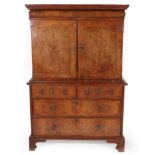 ~ A George I Figured Walnut and Feather-Banded Cabinet on Stand, early 18th century, with cushion