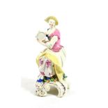 A Bow Porcelain Figure of a Lady Musician, circa 1760, seated playing the tambourine, on a scroll