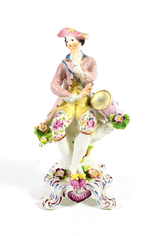 A Bow Porcelain Figure of a Drummer, circa 1765, modelled seated, his drum at his side, on a tall