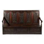 A Joined Oak Settle, late 17th/18th century, the back support carved in relief with five panels of
