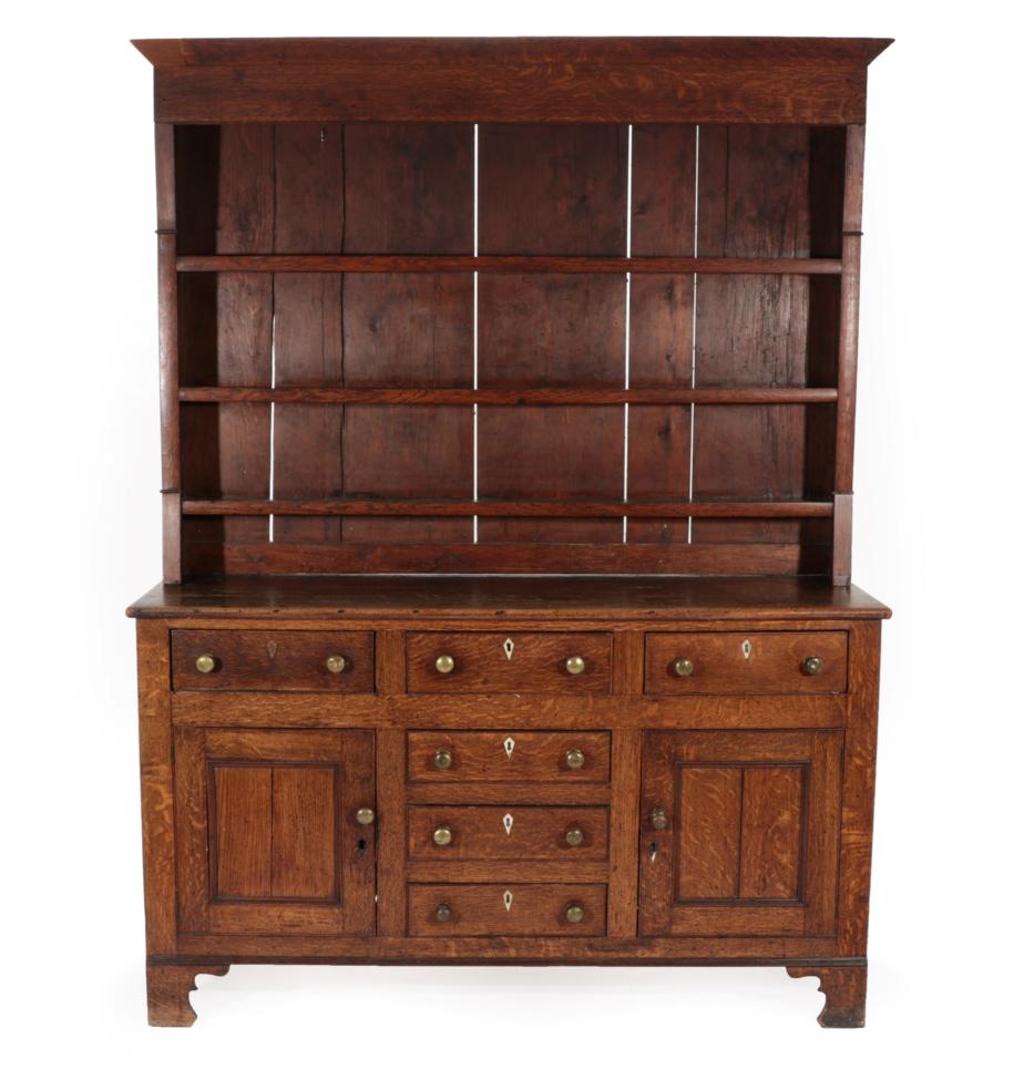 ~ A George III Oak Dresser and Rack, late 18th century, with three fixed shelves, the base with an