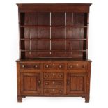 ~ A George III Oak Dresser and Rack, late 18th century, with three fixed shelves, the base with an