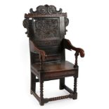 A 17th Century Joined Oak Wainscot Armchair, dated and initialled 1605 AID, the scrolled top rail