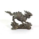 A Chinese Bronze Figure of a Kylin, Qing Dynasty, standing four-square on a stylised wave and scroll