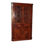 A George III Mahogany and Boxwood Strung Freestanding Corner Cupboard, circa 1800, the moulded