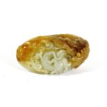 A Chinese Celadon and Russet Jade Pebble, Qing Dynasty, carved with carp amongst waves, 8cm long.
