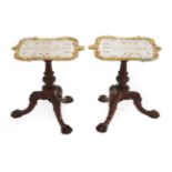 A Pair of Carved Rosewood and Parcel Gilt Tripod Tables, the associated verre eglomise tops on