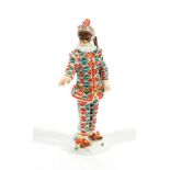 A Meissen Porcelain Figure of Harlequin, 20th century, standing wearing a feathered cap, mask and