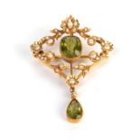 A peridot and seed pearl brooch/pendant, measures 2.7cm by 4.3cm (a.f.) . Gross weight 4.60 grams.