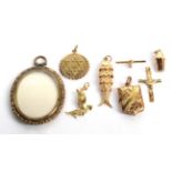 Nine charms/pendants, including two 9 carat gold examples, an 18 carat gold bird example, a cross