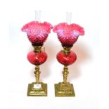 ^ A pair of cranberry glass oil lamps with brass bases and pink and cranberry glass shades, height