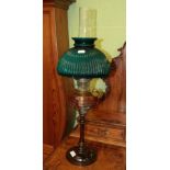 A turned wooden and copper oil lamp with green glass shade