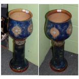 A pair of Royal Doulton blue glazed stoneware jardinieres on stands