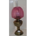 A Victorian oil lamp, with a cranberry glass shade