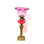 ^ A Victorian brass oil lamp with cranberry glass reservoir, height excluding chimney 56cm