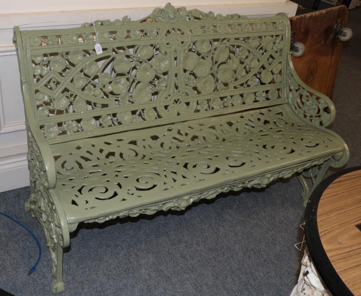 A reproduction green painted metal garden seat, 130cm wide