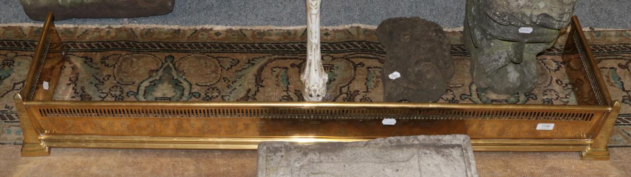 Brass fire curb with Egyptian decoration and obelisk form corners, 139.5cm wide