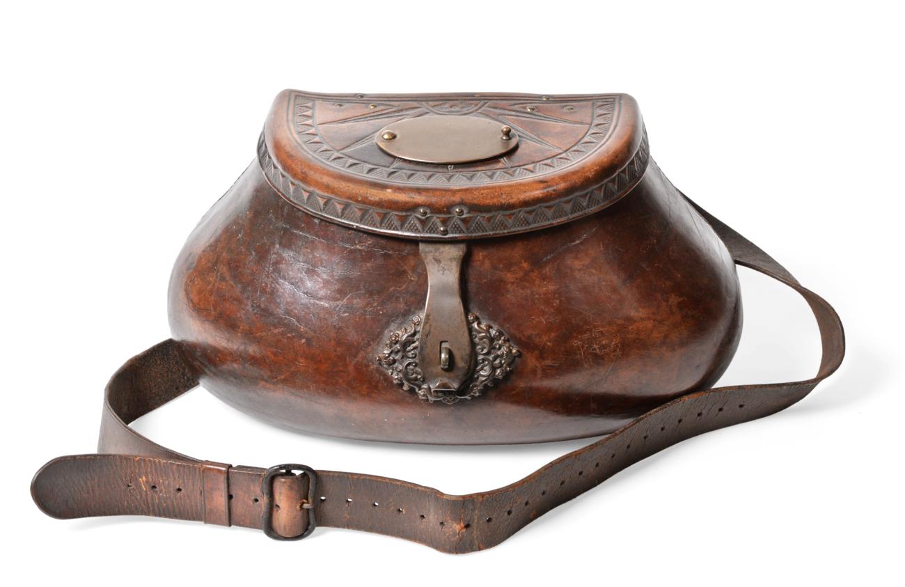 A good 18th century leather pot-bellied fishing creel, the hinged cover tooled with a sunburst