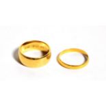 An 18 carat gold band ring, finger size K; and a 22 carat gold band ring, finger size K1/2. 18 carat