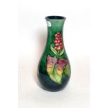 A Walter Moorcroft Arum Lily pattern vase, on a green ground, impressed factory mark and blue