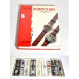 Nine Swatch watches in plastic cases, all with new batteries and a Swatcher Collectables book