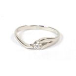 A platinum diamond solitaire ring, a round brilliant cut diamond in a split shoulder tension