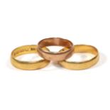 Two 22 carat gold band rings, finger sizes N1/2 and P1/2; and a 9 carat gold band ring, finger