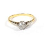 A diamond solitaire ring, the old cut diamond in a white claw setting, to a yellow tapered