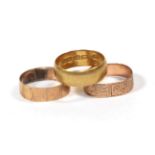 A 22 carat gold band ring, finger size K1/2; and two 9 carat gold patterned band rings, finger sizes