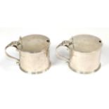 A pair of George V silver mustard-pots, by Thomas, London, 1934, drum-shaped and with blue glass