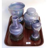 Three Ruskin purple lustre vases together with a Ruskin ginger jar and cover, each with wooden stand