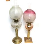 Two oil lamps with glass chimneys and shadesFirst oil lamp with dents to the base. Glass shade