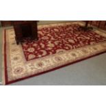 A large Indian carpet, the claret field with an allover design leafy vines enclosed by ivory