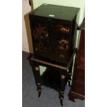 An ebonised cabinet raised on a stand with spiral turned legs